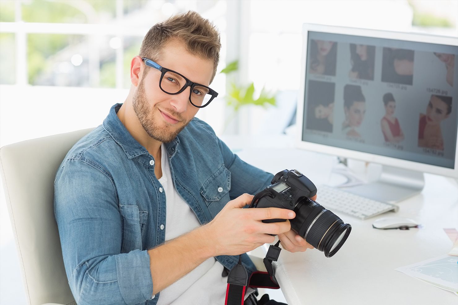 Photographer in a denim shirt holding a camera