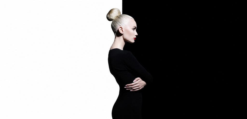 Model in profile on a split white and black background